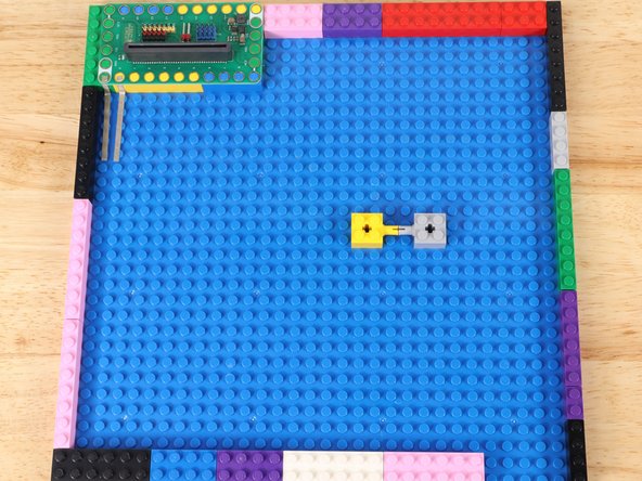 Mount the servo to some LEGO bricks attached to the baseplate.