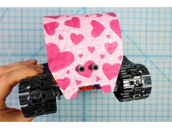 Wrap the paper over the body and use two more pin/beam sets to secure the front as shown.