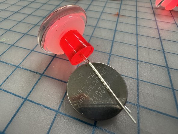 Place a coin cell battery between the legs of the LED (long leg touches positive).