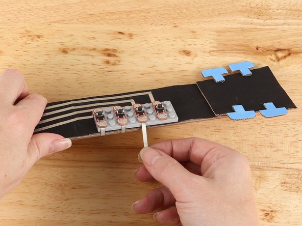 Replace the button to help secure the tape path in place.