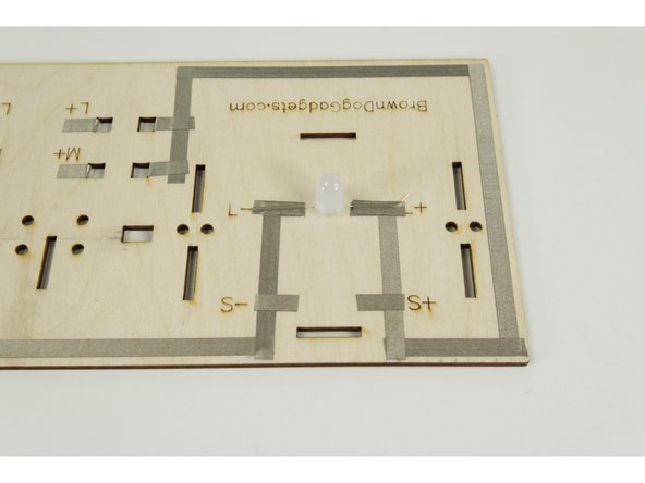 Turn the base around so the back of it is facing you. You'll see an L- and L+ in the center of the section where the house will sit.