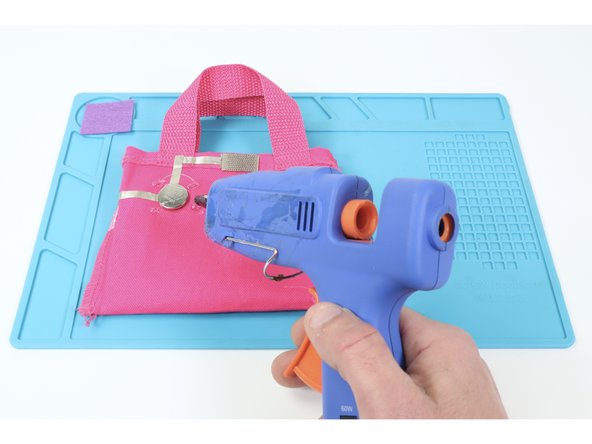 So that your battery doesn’t get knocked loose when putting things in your bag, cut and hot glue a small square of felt just a little bit bigger than your battery where shown.