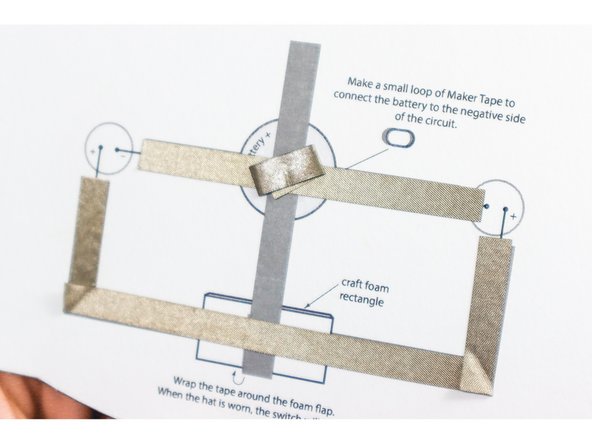 Make a small loop of Maker Tape to connect the battery to the negative side of the circuit as shown.