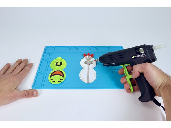 Use a hot glue gun to lay a bead of glue around the perimeter edge of the shape on the battery side (it's perfectly ok to go over your Maker Tape paths).
