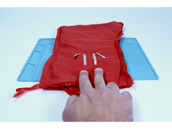 Recall that the two inner legs are the shorter legs. Cut two 2&quot; pieces of Maker Tape. Peel and stick one to each of those two inner (-) legs and then TO the stocking as pictured (half on the leg/half on the felt). 