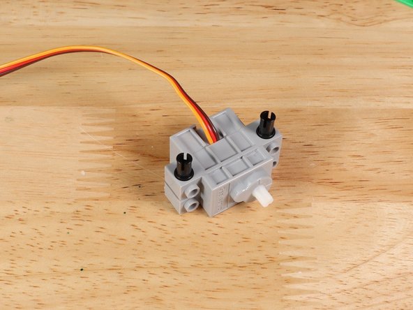 Connect the servo to a LEGO technic beam with the wires at the bottom. In this guide we used an 11-hole long beam. You can also use a different size and modify accordingly.