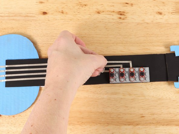 Place the button on top of the tape path to secure it in place.