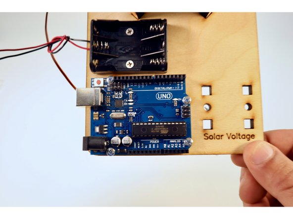 Position the Arduino over the holes next to the battery pack with the USB port orientation as pictured.