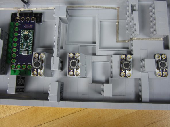 Use a small piece of double sided foam tape to secure down all the Pushbuttons.