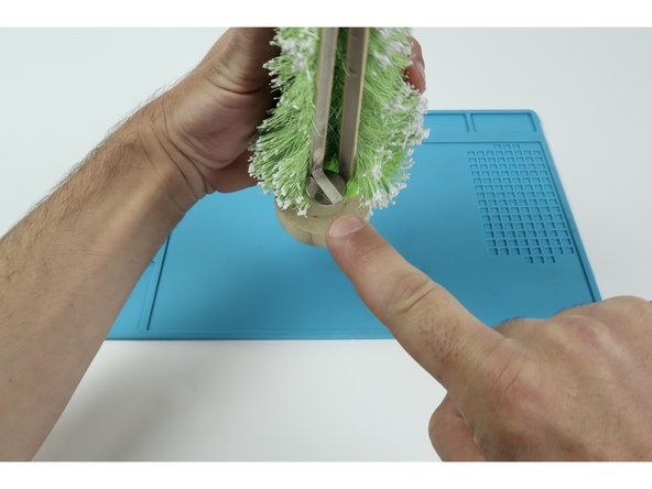 Apply hot glue to one side of two separate popsicle sticks and press each into place vertically on either side of the part as shown. Now you have a two separate flat surfaces that your conductive Maker Tape paths can be pressed to when connecting the LED at the top to the voltage source that will be below.