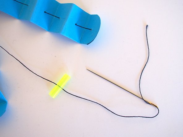 Sew one of the pieces of thread onto the straw
