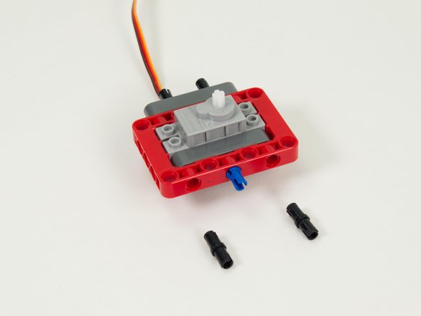 Add two pins to the front of the frame piece as shown.