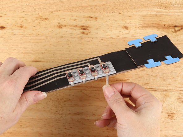 Replace the button to help secure the tape path in place.