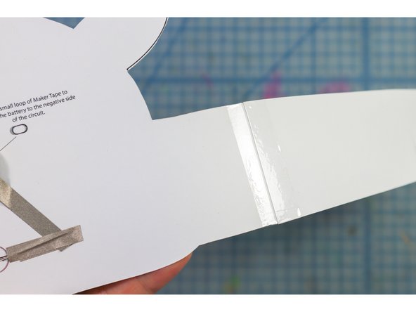 Tape the headband pieces to the sides of the paper as shown.