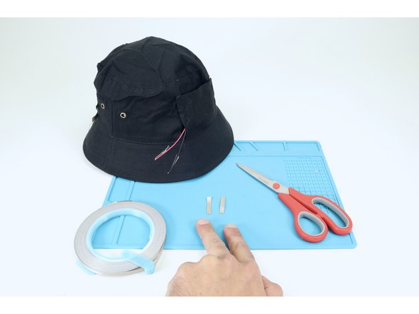 Cut two small pieces of Maker Tape and sandwich the metal ends of each of the two wires leading from the battery pack just as you had each of the individual LED legs earlier. The black wire is negative and the red wire is positive.