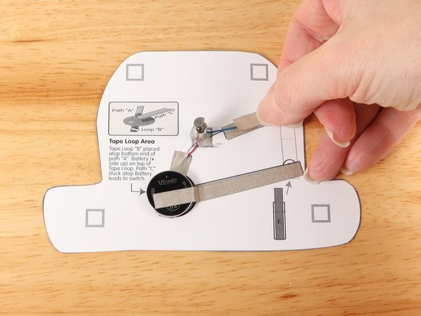 Add another piece of Maker Tape to  Tape Path D. pressing it down atop the blue wire.