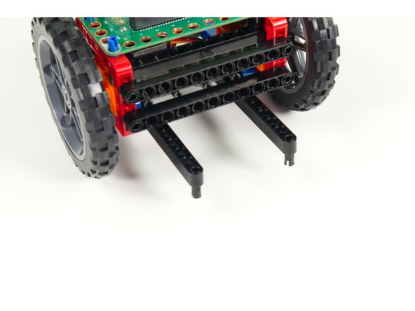 Add two short black pins to the first holes in the beams that were added in Step 5.