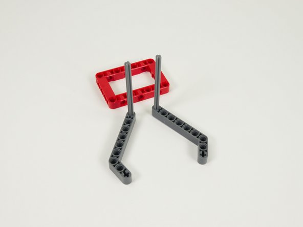 Slide the axles into the second red frame as shown.