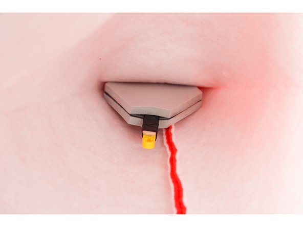 Insert the rest of the assembly inside the hat. It's easiest to do this in two steps: detach the foam piece and place it inside, then place the headpiece inside, then carefully re-attach the stick to the motorhead inside the hat.