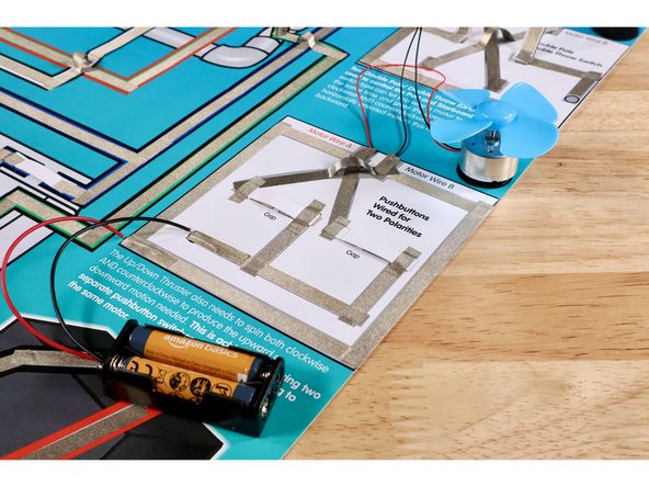 Push the right button down into contact with the contact points below; bridging the gap and completing this part of the circuit. Observe the direction of rotation at the motor.