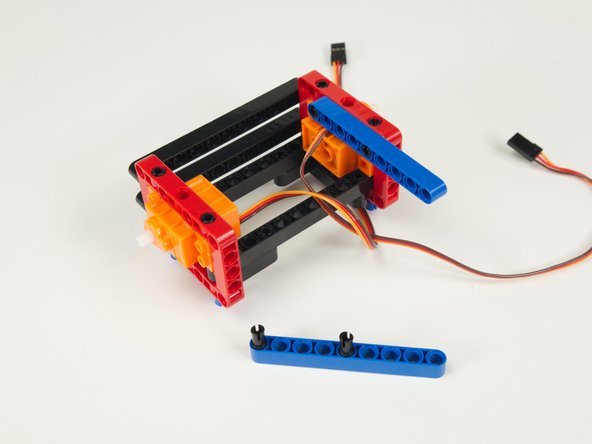 Press one of the blue beams into place on the inside of the frame as shown.