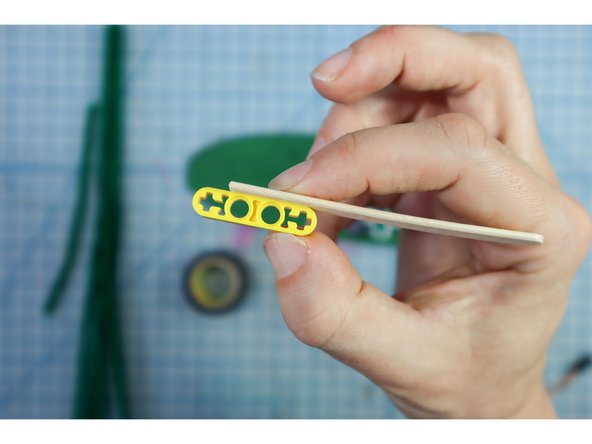 Use electrical tape to attach it to the LEGO, making sure not to cover the &quot;+&quot; at the end, as shown.