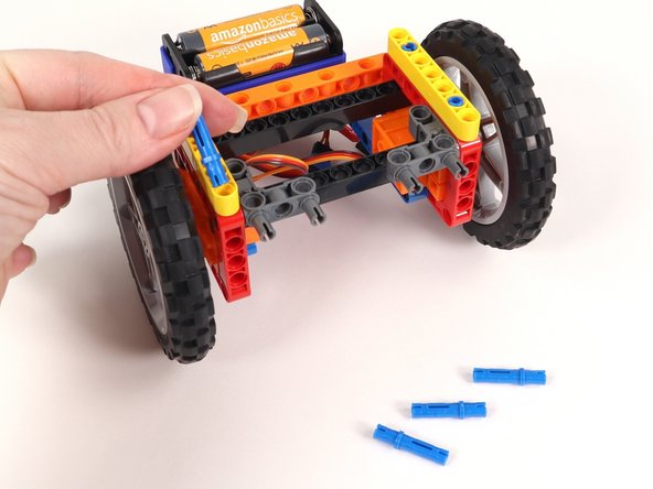 Add four blue pins into the yellow beams as shown.