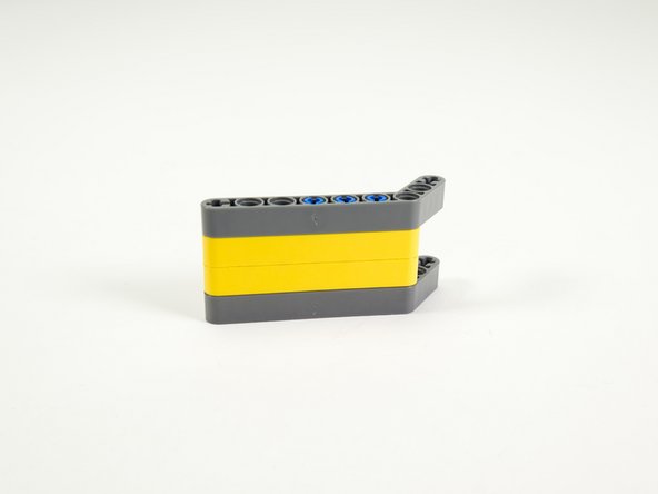 Finally, add the top gray angled beam, pressing it onto the pins so it fits tight against the beam below it.