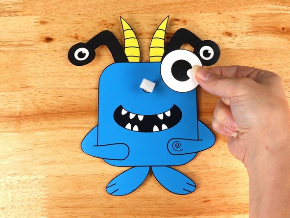 Add another square of double-sided tape onto the shaft of the motor, and then stick the eye to it.