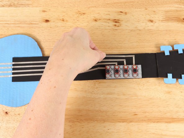 Place the button on top of the tape path to secure it in place.