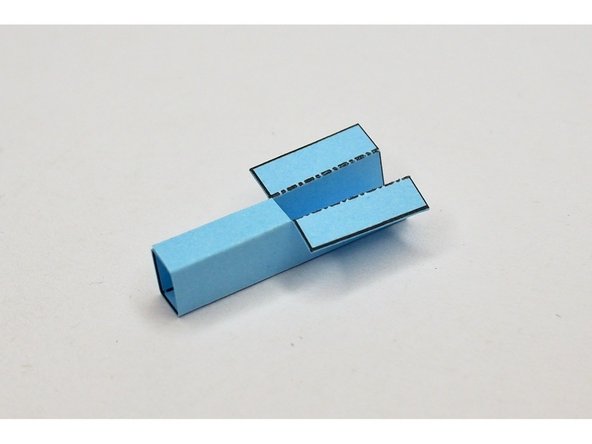 Fold and glue the wing holder so that the bottom forms a rectangle and the top has the tabs facing outwards.