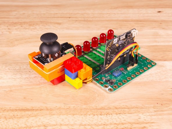We attached two 2x4 LEGO Bricks to the bottom of the 3D printed holder to allow it to snap onto the LEGO Baseplate a bit easier. (We also added a few small bricks to hold the ribbon cable in place.)