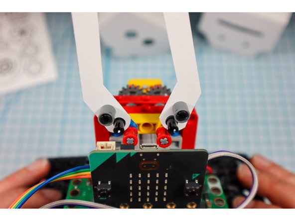 Disconnect the pins and place the arms onto the half beams. Then, replace the pins.