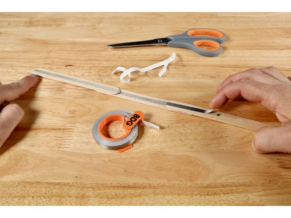 Flip the wand handle over. Measure, cut, peel, and stick a second piece of Maker Tape that reaches from the end furthest from the mark TO the mark itself.