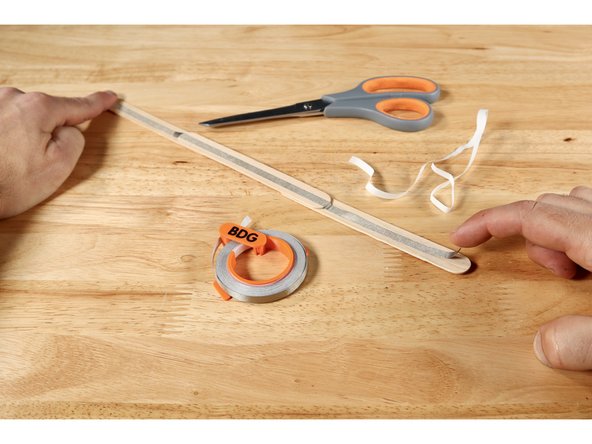 Measure, cut, peel, and stick a Maker Tape path end-to-end on the side of the wand handle that does not have the mark for your finger. Do NOT curl any tape from this side to the opposite side.
