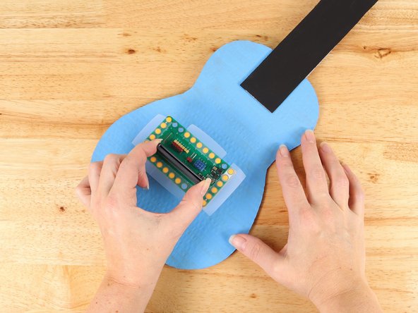 Plan out the placement of your Bit Board. Ideally you should have Pins 12, 13, 14, and 15 facing the neck of the guitar. These pins will connect with Maker Tape up to the buttons and the less turns in the tape paths the better.