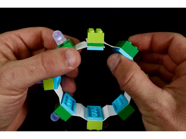 When you wish to wear your bracelet, simply bring the remaining punched end around and lay those holes atop the studs from the 2 plate sandwich and press your remaining 2x4 brick on top to secure it into the bracelet shape. 