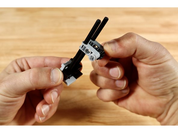 Seat each of the long axle ends from the first part of the build into the axle holes of the beveled gear build and slide it all down toward the bottom brackets.