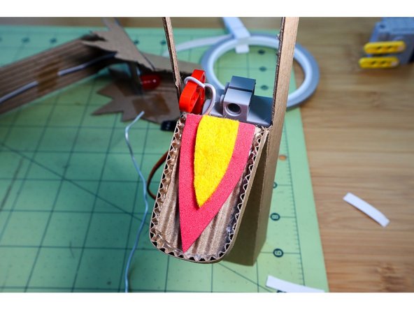 Glue a piece of armature wire to the jaw, and connect it to the LEGO Beam on the end of the servo motor. Glue the motor in place.