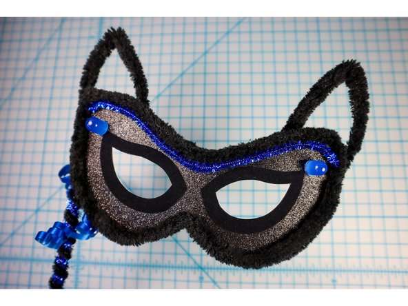Wrap pipe cleaners around a wooden dowel, then glue the dowel to the back for a masquerade style handheld mask.