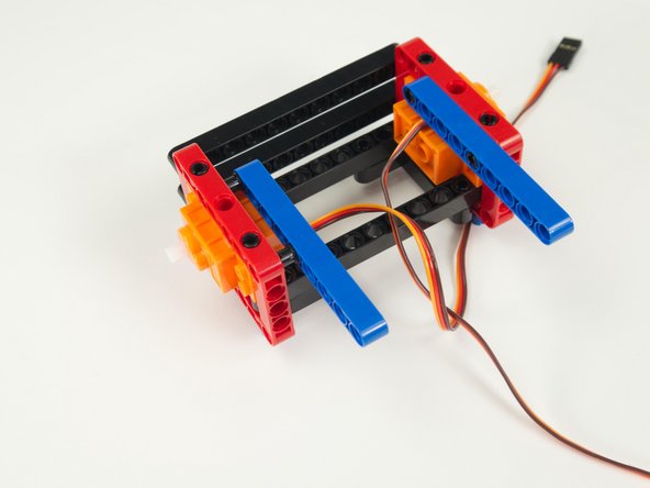 Add the second blue beam, pressing it into place opposite the previously added beam.