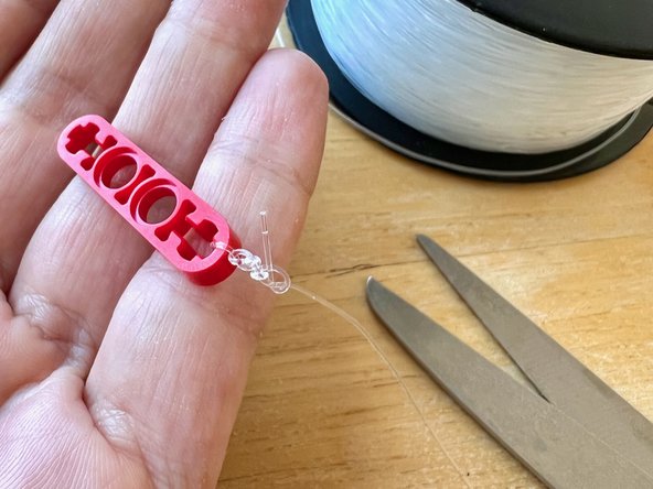 Cut a piece of the fishing line long enough to reach across your room, adding about 6 inches extra.