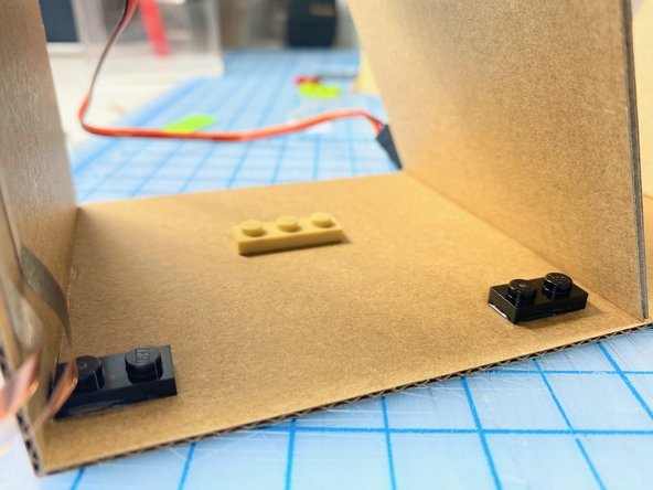 To keep the micro:bit in the same spot, but be able to remove it easily while building, we used superglue to attach the LEGO to the cardboard to match the holes of the Bit Board. To get the positioning right we placed the Bit Board over the LEGO while gluing, then removed it to let it dry.