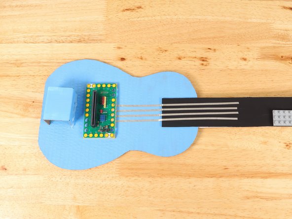 Using 1/8" Maker Tape, adhere the end of the Maker Tape to the center of the stud underneath Pin 12 of the Bit Board.