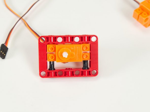 Slide the servo inside the red frame and press it down onto the pins.