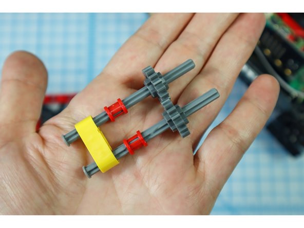 Push the pieces down until they stop, interlocking the gears.