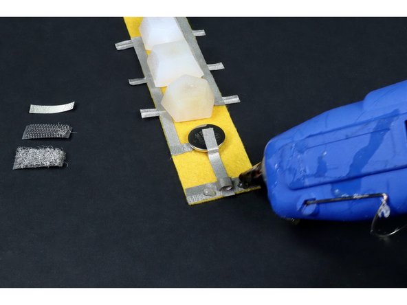 Press either the hook or the fuzzy loop portion of your chunk of conductive hook and loop over the tape loop and glue as shown in photo 3.