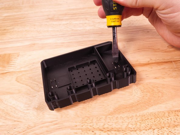 We used a slotted screwdriver to press the legs flat. They bend easily but you'll still probably need a tool do to it. (A pen or other writing implement could also work.)