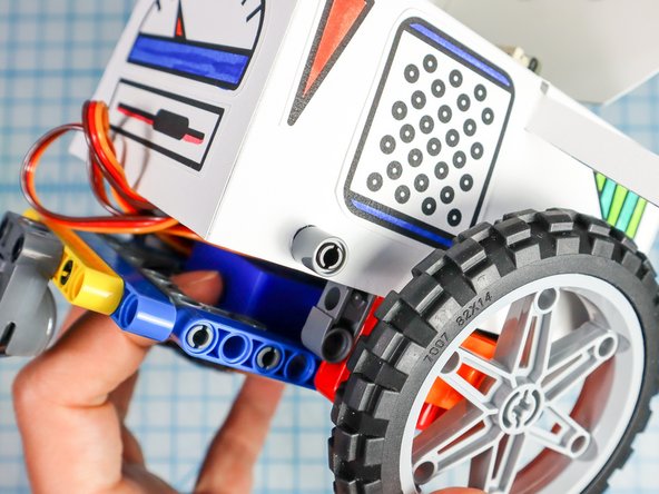 Use the pin/beam pieces to attach the body to the rover as shown. There is a connection behind the wheel on both sides and there are two connections in the front.