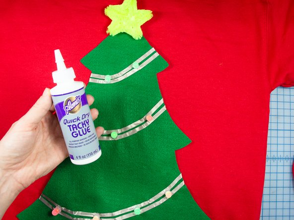 Use tacky glue to glue the tree to the center of the sweatshirt. Leave a gap in the glue around the battery pack.